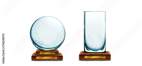 Glass trophy with laurel on wood stand with golden plate. Realistic vector set of transparent plexiglass crystal award on wooden base. Mockup of blank glossy acrylic winner prize cup on pedestal.