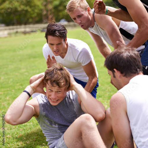 Man, sit ups for fitness and cheers from team with support and coaching, exercise and training on sports field. Challenge, action and core workout outdoor with athlete friends, motivation and help © MV/peopleimages.com