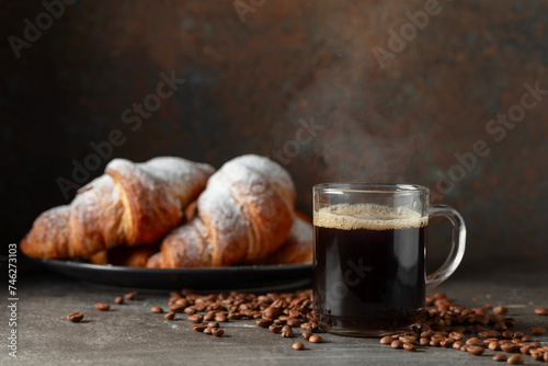Croissants and black coffee on a kitchen table.