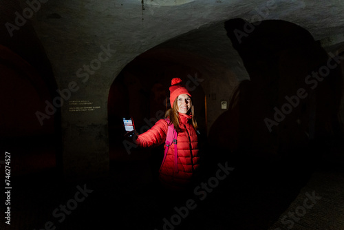 Dungeon. A tourist in a dark tunnel in an ancient fortress.