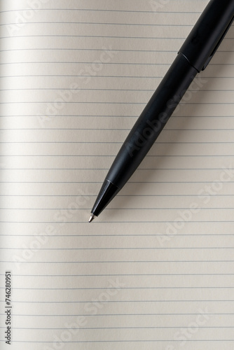 Top view of black ballpoint pen on lined note paper