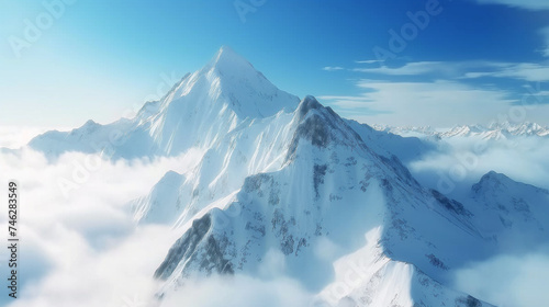 Close up of majestic snowy mountain top above cloud with fog in background of blue sky. Winter concept of nature and landscape.