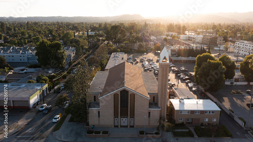 Los Angeles, California, USA - May 7, 2023: Sunset light shines on a church and urban core of downtown Canoga Park. photo