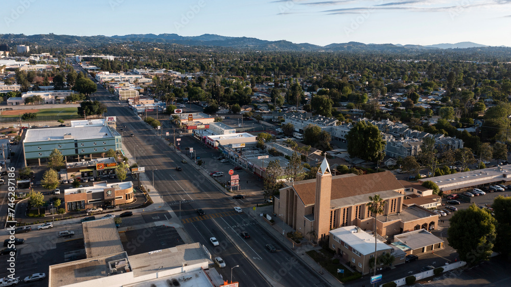 Los Angeles, California, USA - May 7, 2023: Sunset light shines on a church and urban core of downtown Canoga Park.