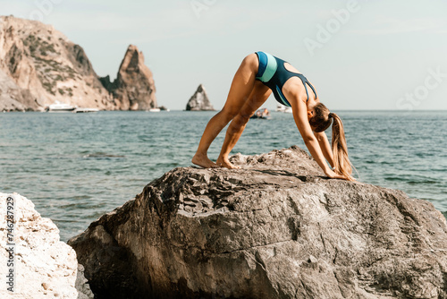 Yoga on the beach. A happy woman meditating in a yoga pose on the beach, surrounded by the ocean and rock mountains, promoting a healthy lifestyle outdoors in nature, and inspiring fitness concept.