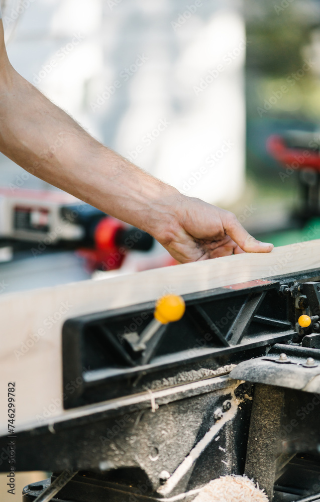 Carpenter precisely cutting wood with a miter saw. Carpenter precisely cutting wood with a miter saw.