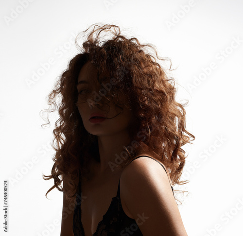 curly Hair Girl silhouette. Beautiful young Woman in white studio