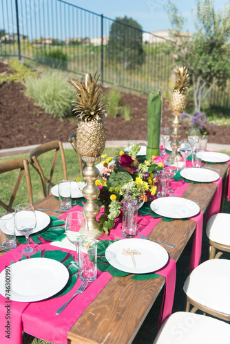 Tropical Theme Table Setting with Pineapples and Flowers photo