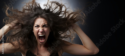 An enraged woman with her hair blowing in the wind.