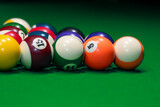 Many colorful billiard balls on green table