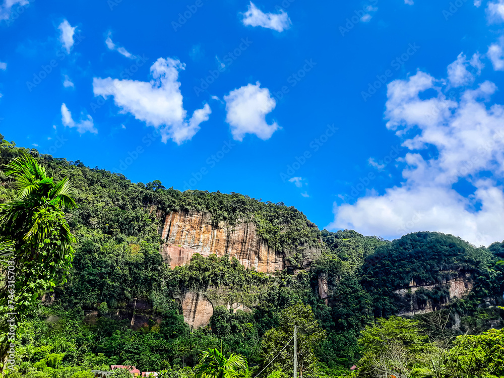 Fototapeta premium View of the Harau Valley with cliffs covered with green plants and trees during the day