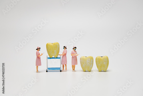 Figure yellow teeth with sweet candy were forced by nurse to checking dental examination and treatment  on white background