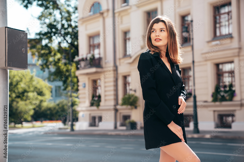 Portrait of young beautiful brunette woman wearing nice trendy suit black jacket clothes. Sexy confident model posing in the street at sunny day. Fashionable female outdoors.