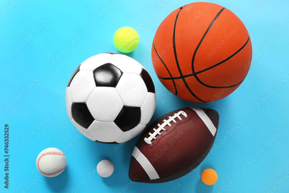 Many different sports balls on light blue background, flat lay