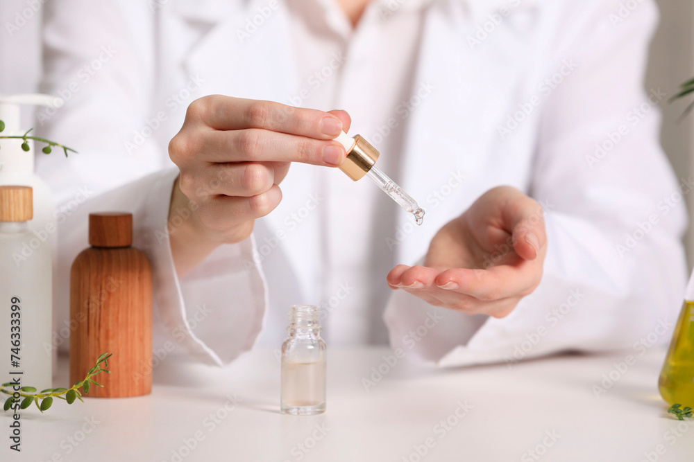 Dermatologist testing essential oil at white table, selective focus Dermatologist testing essential oil at white table, selective focus