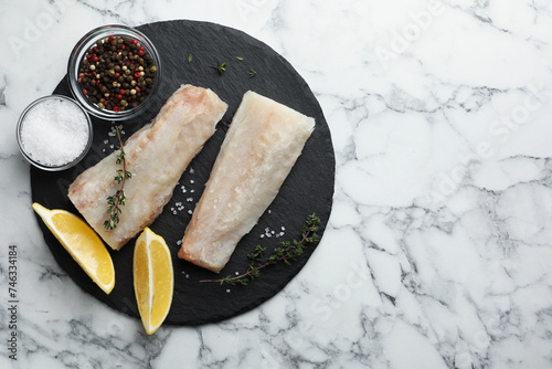 Canvastavla Fresh raw cod fillets, spices and lemon on white marble table, top view