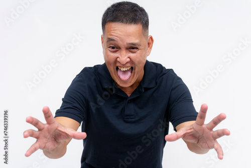 A lusty and pervy middle aged asian man reaching out with both hands, toungue out. Isolated on a white background.