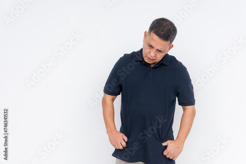 Foto A middle-aged Asian man looking down with a guilty expression, conveying regret