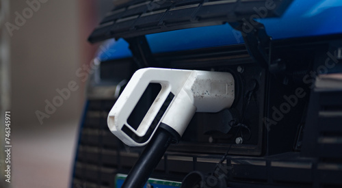 Close-up of an electric car being charged with an electric vehicle charger.