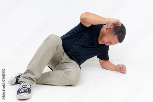 Tableau sur toile A scared middle aged Asian man drops on the ground cowering and frozen in fear with a defensive posture