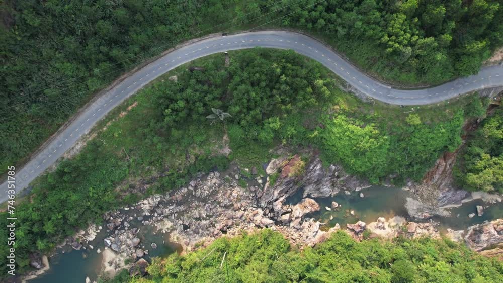 Aerial view of a winding road through the lush Annamite Range in Vietnam, showcasing the natural beauty and rugged terrain of Southeast Asia Aerial view of a winding road through the lush Annamite Range in Vietnam, showcasing the natural beauty and rugged terrain of Southeast Asia