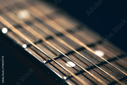 Foto Part of an acoustic guitar, guitar fretboard on a black background
