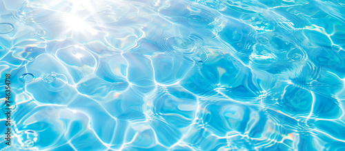 Clear blue water background with sunlight reflecting off its surface. Gentle ripples  intricate patterns. Relaxation  wellness  pool party concept.