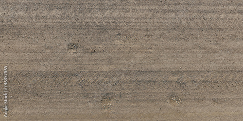panorama of road from above on surface of gravel road with car tire tracks in countryside