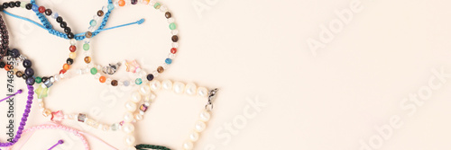 Banner with handmade bracelets made of beads and cords on a beige background.