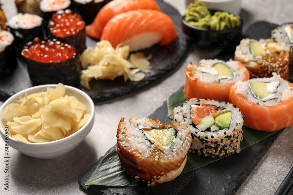 Delicious sushi rolls and ginger on light grey table, closeup
