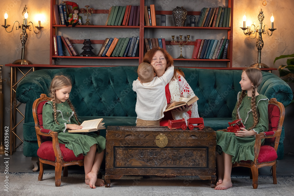 Happy grandma and grandchildren reading book together at home