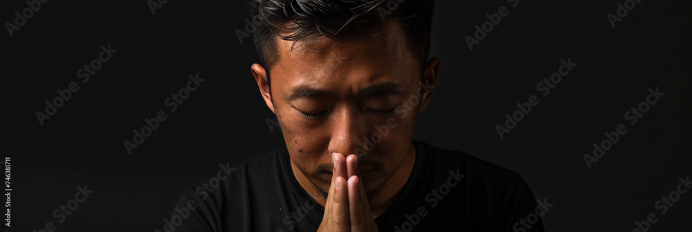 Asian man prays to god on black studio background - obrazy, fototapety, plakaty 