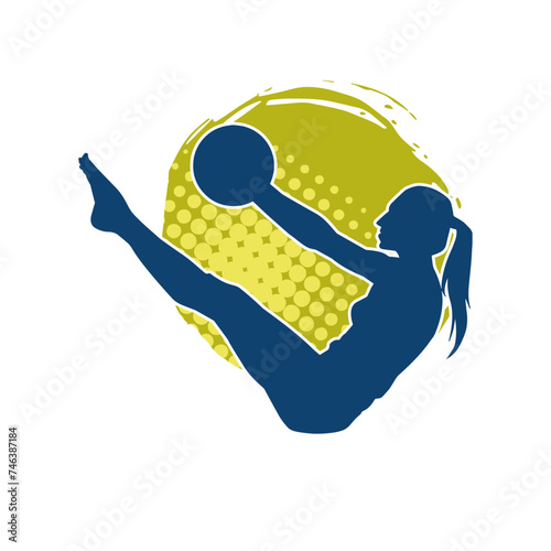 Silhouette of a slim sporty woman doing pilates exercise using gym ball. Silhouette of a sporty female doing physical exercise using fitness ball. 