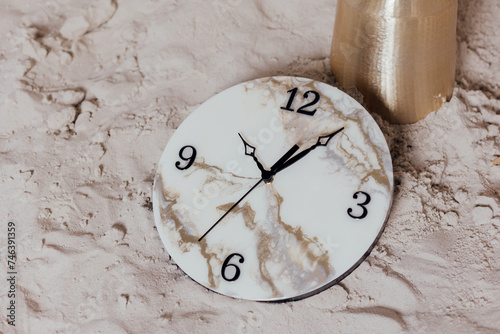 Round wall clock. Clock hands and dial. On the sand. photo