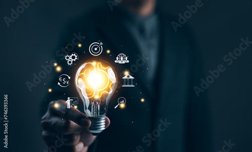 Idea solution business strategy concept. Businessman hand holding light bulb with business icons. Digital marketing, Financial and banking, Internet connection application technology, Business goals,