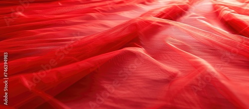 A bed is fully covered in red sheets and sheets, creating a bold and vibrant look. The red tulle background adds texture, while a funky spotlight shines on the red carpet.