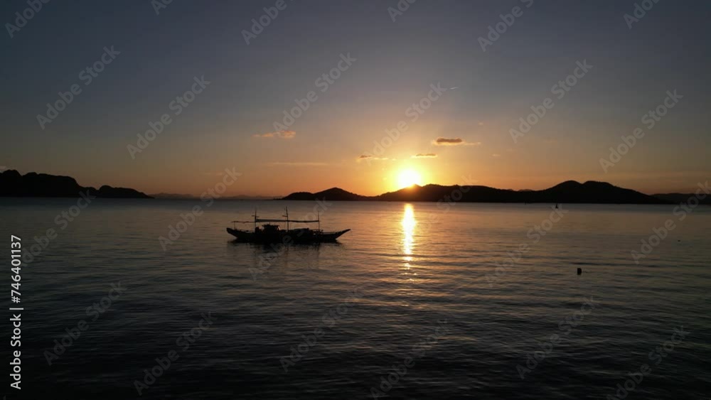 Silhouette of a boat on the ocean at sunset