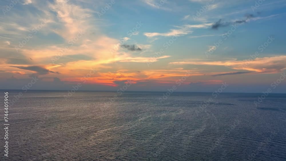 As day bids farewell, a drone captures the ocean's edge merging with a sky ablaze in hues of blue, orange, and red. A sunset spectacle from above. Bird's eye view. Ocean loop video background. 4K HDR. As day bids farewell, a drone captures the ocean's edge merging with a sky ablaze in hues of blue, orange, and red. A sunset spectacle from above. Bird's eye view. Ocean loop video background. 4K HDR.