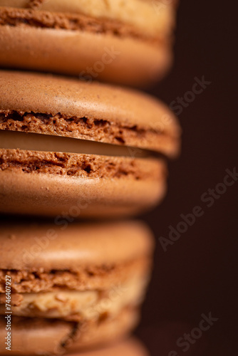 four brown coffee macaron on a brown background