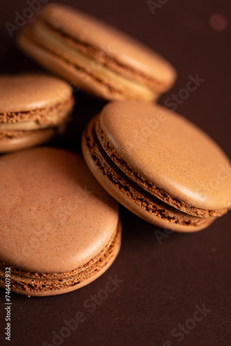 four brown coffee macaron on a brown background