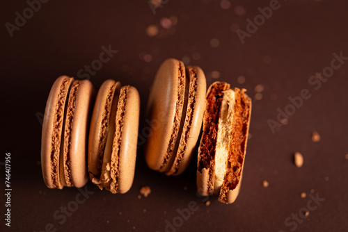 four pieces of brown coffee macaron on a brown background