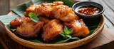 Delicious crispy fried chicken in a bowl with flavorful sauce and small dipping bowl for mealtime indulgence