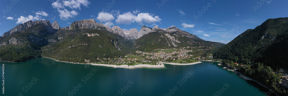 Aerial view of Lake Molveno, north of Italy in the background the city of Molveno, campanile basso, cima tosa Italian dolomites. Panoramic view of the Alpine Italian town of Molveno on the lake.