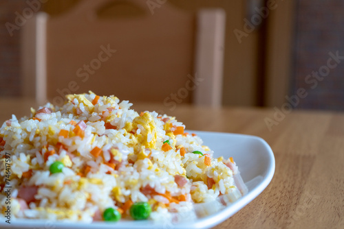 Detalle de arroz tres delicias estilo chino servido en un plato blanco en un restaurante.
