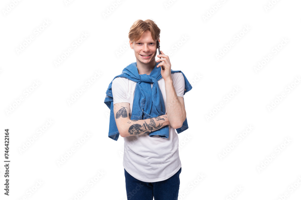 young successful red-haired guy in a blue shirt speaks on the phone young successful red-haired guy in a blue shirt speaks on the phone