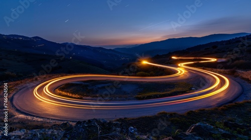 Cars light trails at night in a curve asphalt, mountains road at night, long exposure image
