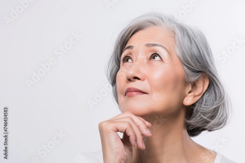 考えている日本人女性おばあちゃんのポートレート（白背景・検討中・思案・老後・年金・悩む）