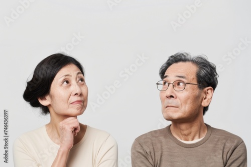 考えている日本人の初老の夫婦（白背景・老後・介護・健康・年金・将来）