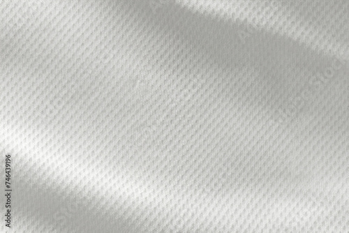 A close-up top view of the texture of a white sports fabric jersey football shirt.