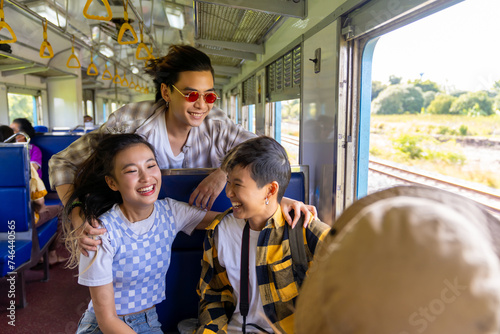 Happy Asian man and woman friends enjoy and fun outdoor lifestyle travel countryside by railroad transportation on summer holiday vacation. Generation z people sitting on train and talking together.